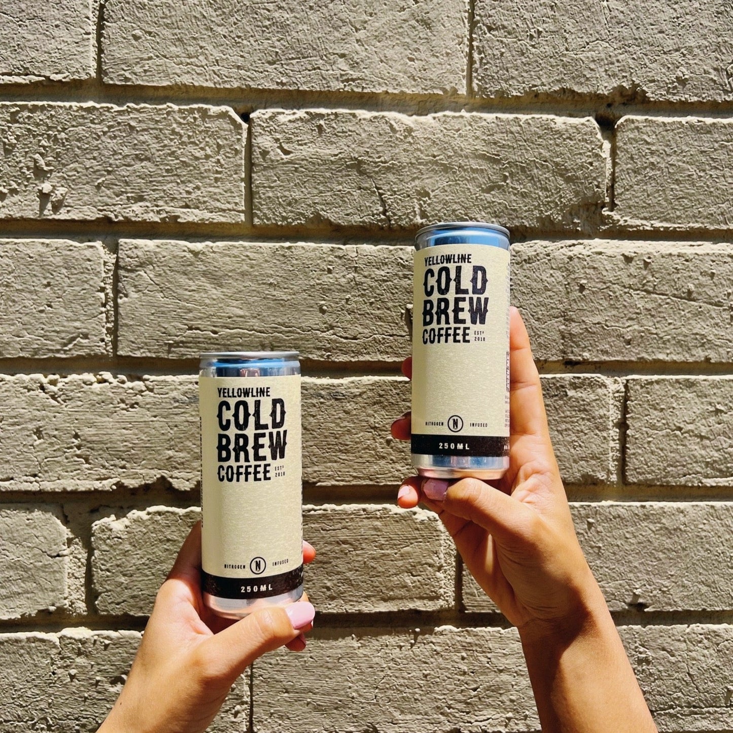 Yellowline Cold Brew Coffee Cans Held in Air